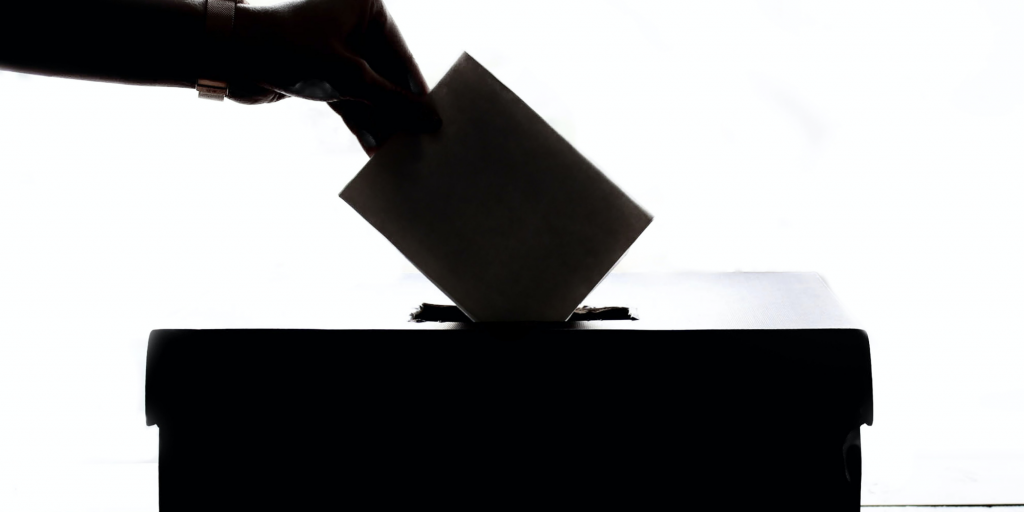 Black voting card being put into a voting box