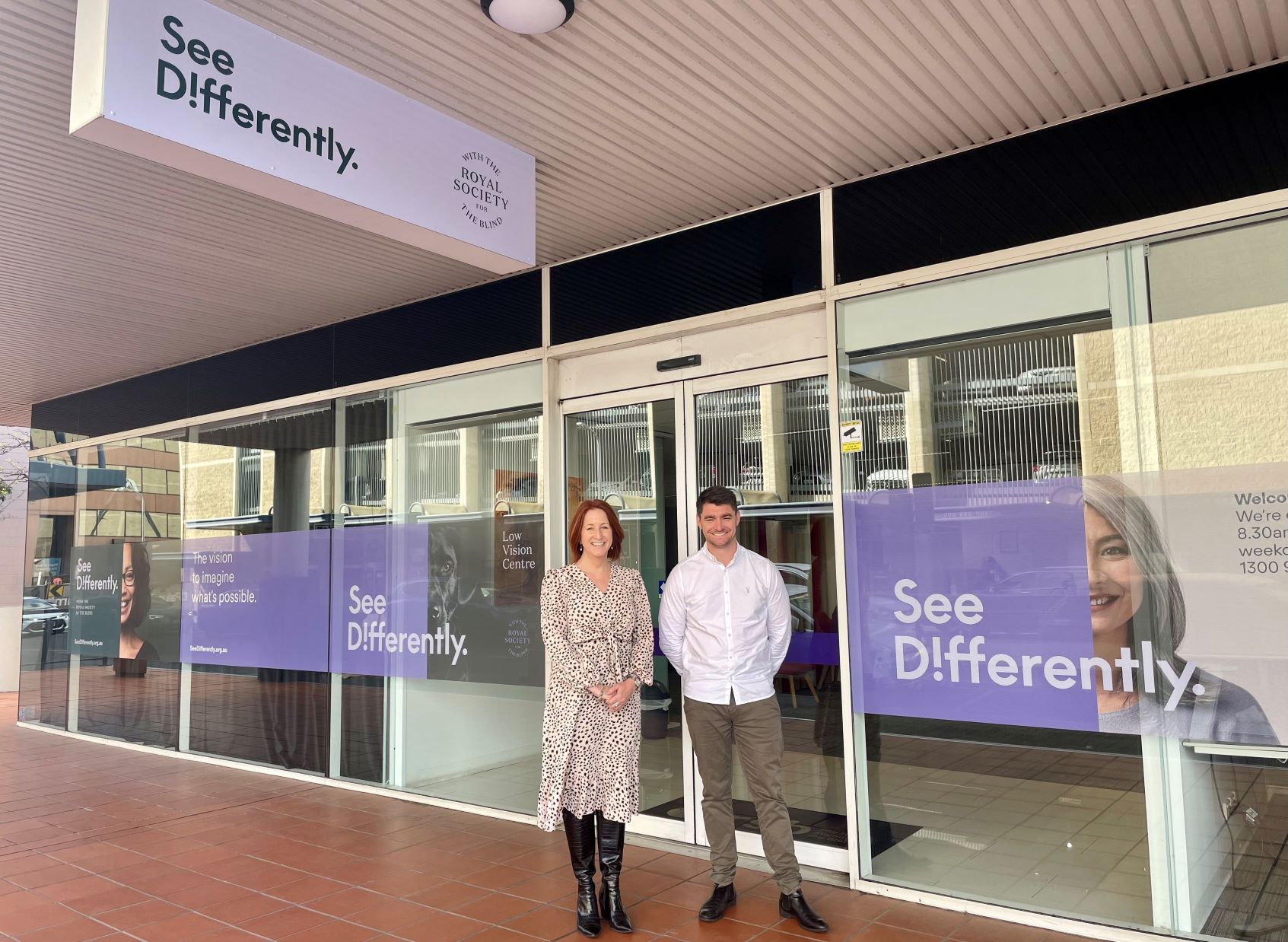 lady and man standing in front of office with 'See Differently' branding