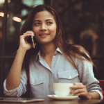 Lady talking on the phone and holding a cup of coffee