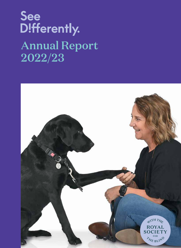The front cover of See Differently's 2022/23 annual report. A picture of a lady with short curly hair is sitting on the floor opposite her black guide dog. She is holding its paw and smiling at the dog.