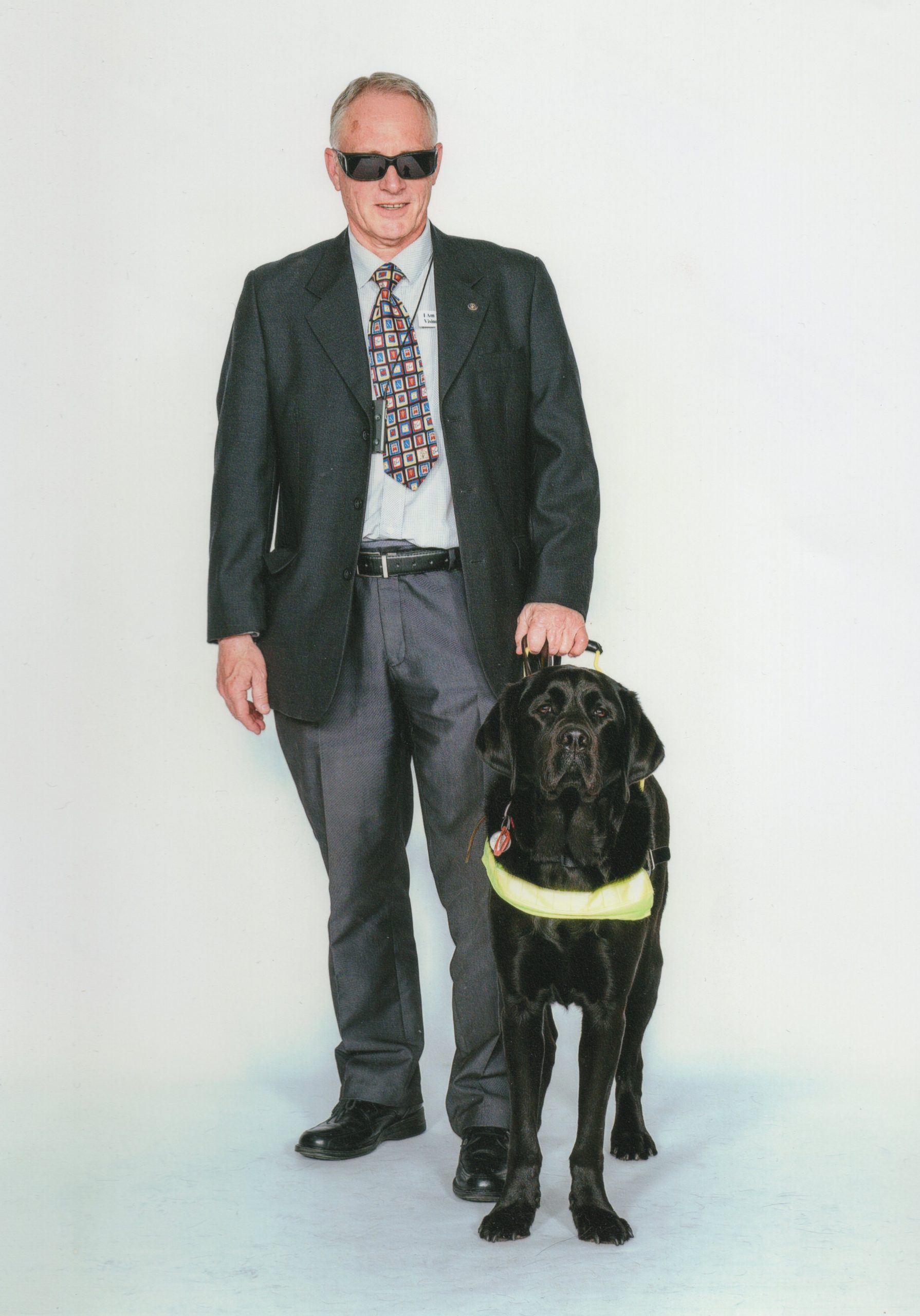 Dr David Squirrell standing next to his black dog Viking