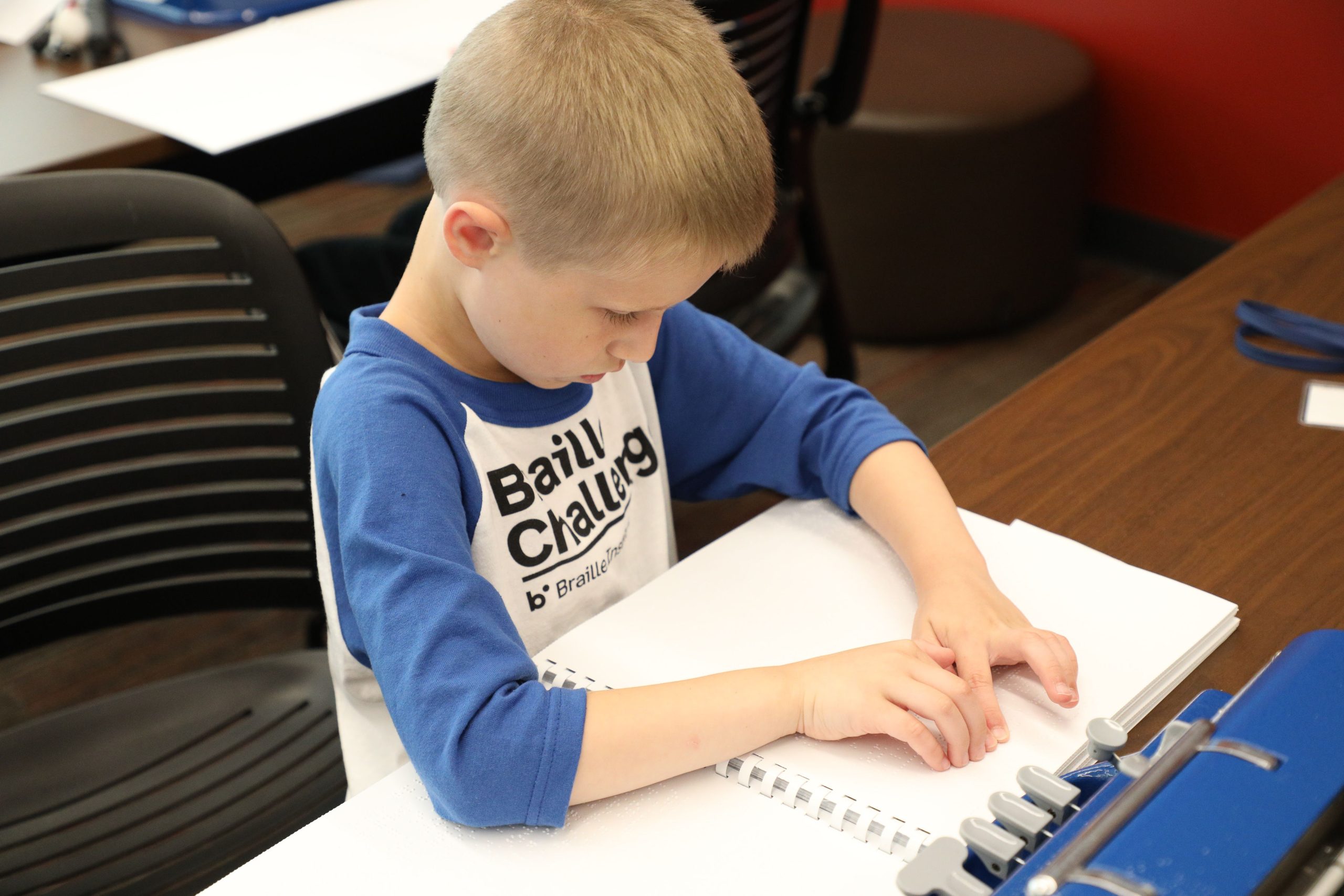 A young boy reading braille.